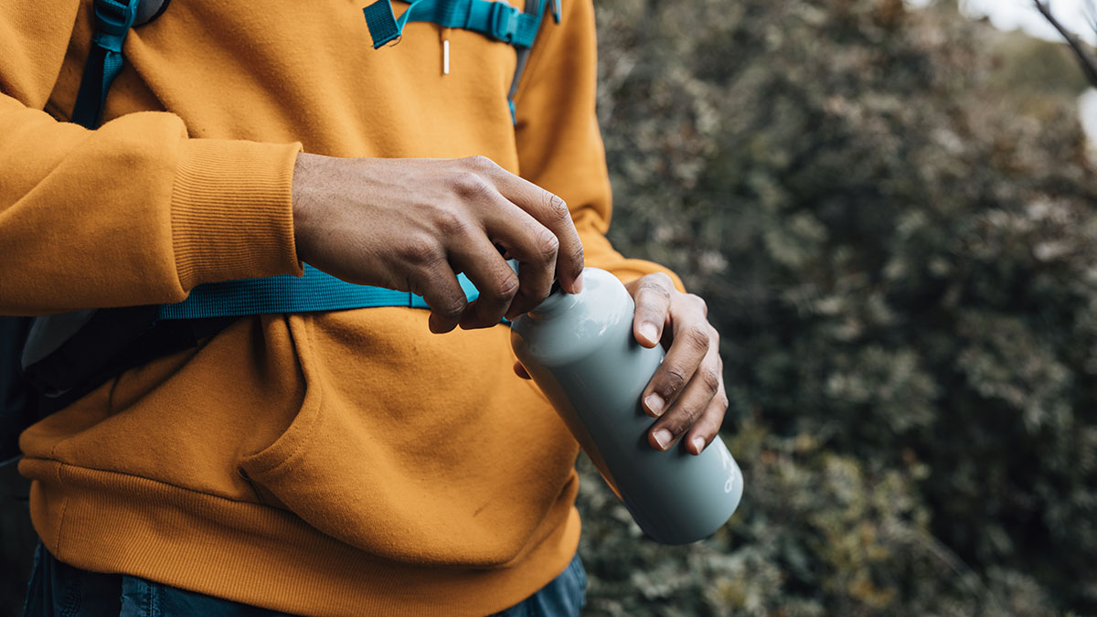man opening lid of a water bottle